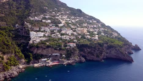 town of praiano italy with lido one fire beach below the cliffs, aerial dolly out