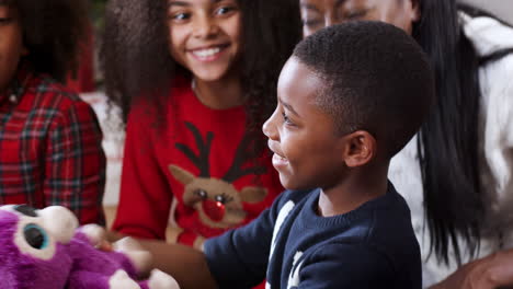 son opening gift as family celebrate christmas at home together