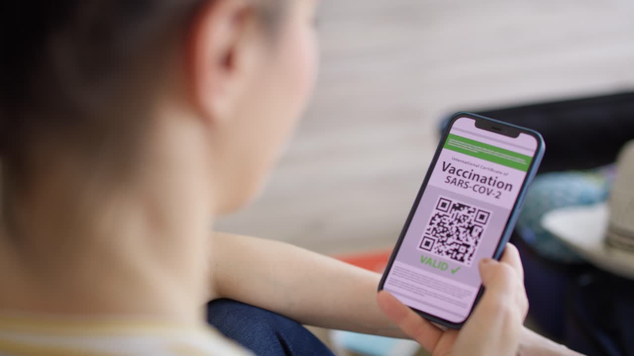 Tracking video of woman holding phone with digital vaccination card