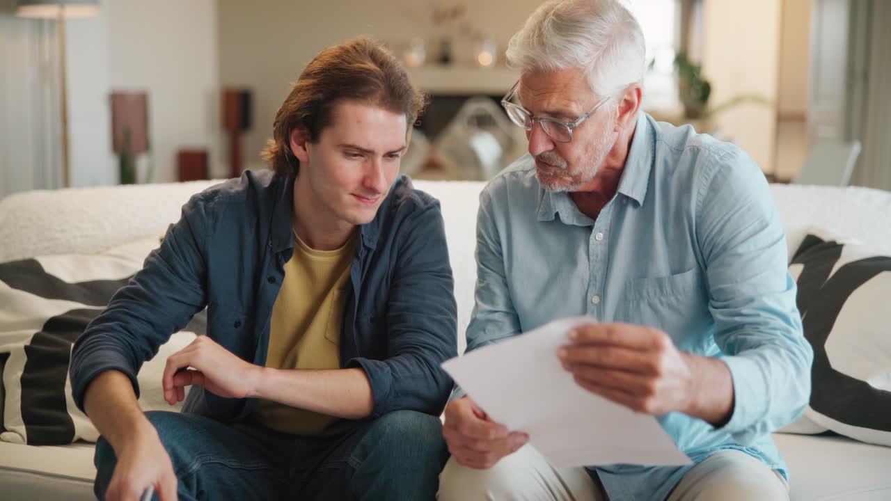Father and son discussing documents on the couch