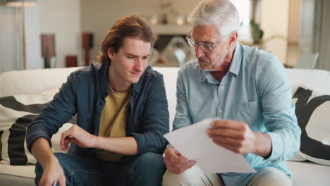 father and son discussing documents on the couch