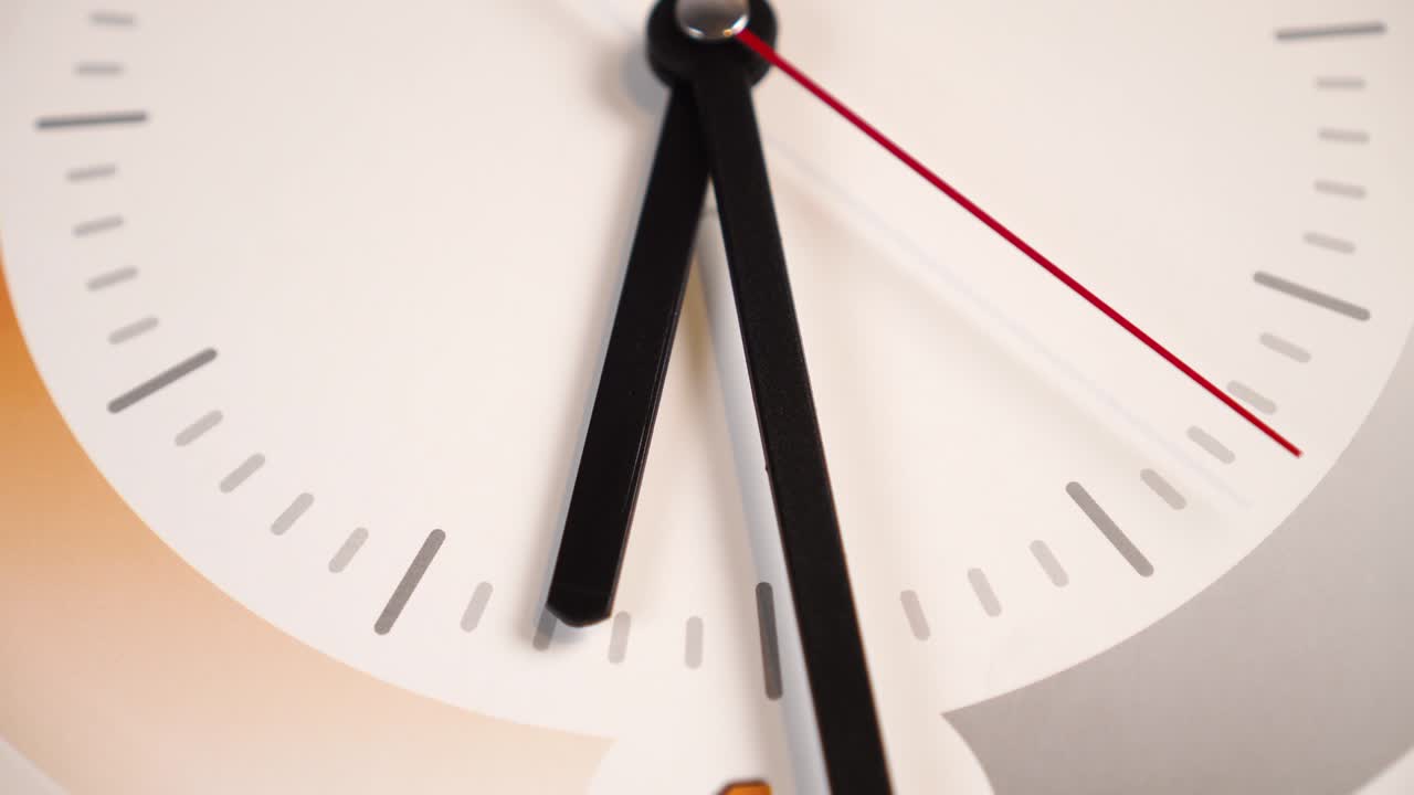 tiempo pasando con una segunda mano roja y manos negras de minutos y horas en un dial blanco con patrones naranja y gris