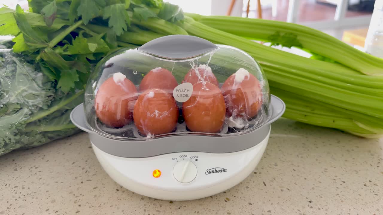 Eggs steaming beside fresh vegetables on counter