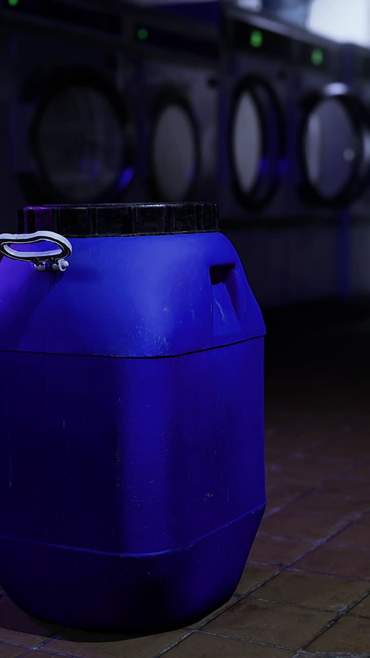 Laundry facility with a blue container in a low lit environment