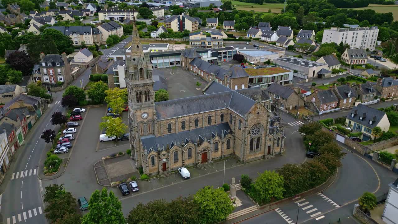 Approaching drone movement to the catholic Saint-Sauveur Church of Plancoet, Côtes-d'Armor, Brittany, France.