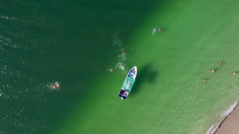 Luftdrohnen-Überflugboot-Mit-Menschen,-Die-Im-Klaren-Wasser-Vor-Conchal-Beach,-Costa-Rica,-4k-Schwimmen