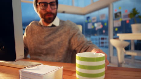 ejecutivo de negocios trabajando en la computadora mientras toma café