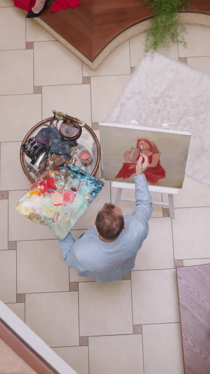 el artista dibuja el rostro de la mujer en el estudio doméstico. el creador de arte toca el lienzo con el pincel imaginando el retrato de la modelo femenina en el estudio. el hombre descansa con una afición creativa