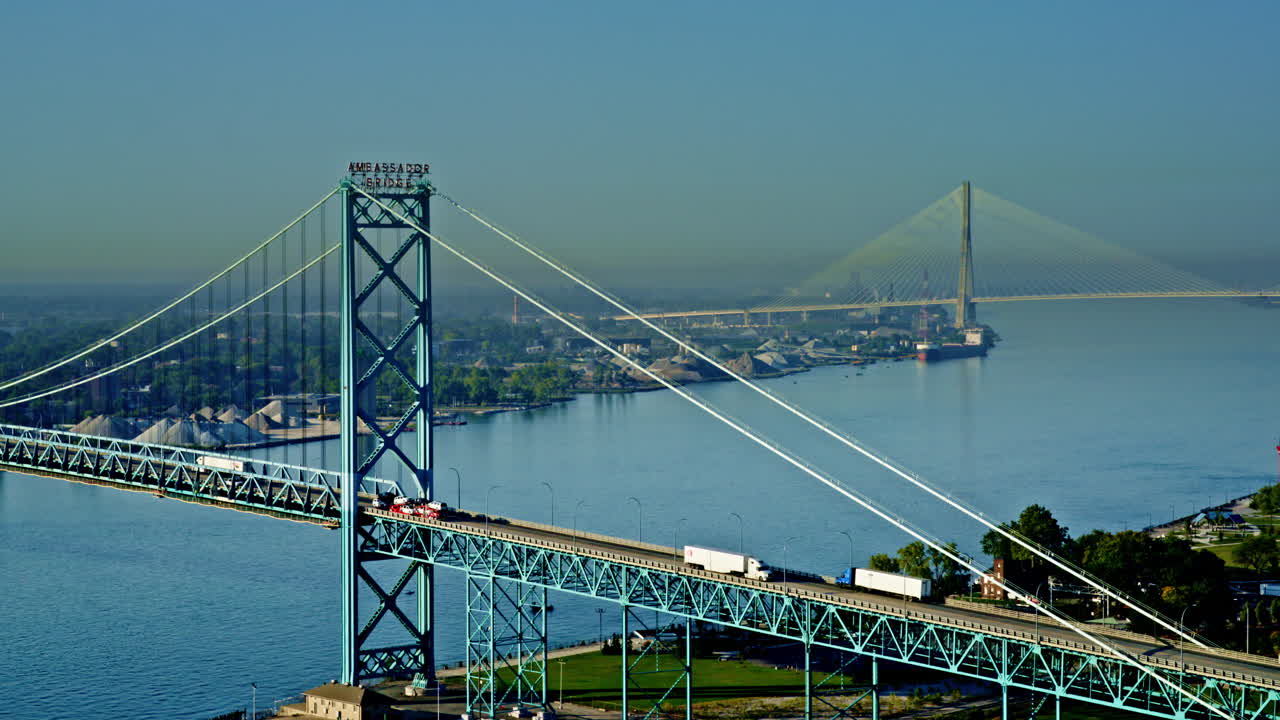 Aerial cinematic perspective over Detroit River, freighter moving gracefully beneath skyline