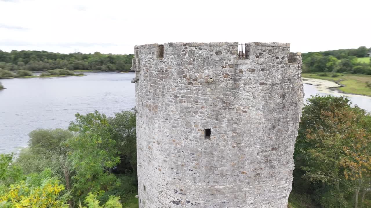 Drone i dynamisk spiral rundt om et borgtårn i søen. Cloughoughter Castle, Irland