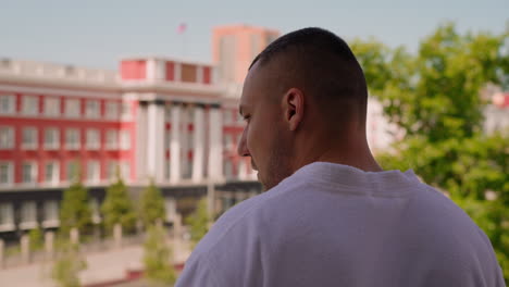 Relaxed-person-smokes-cigarette-on-terrace-of-hotel-room