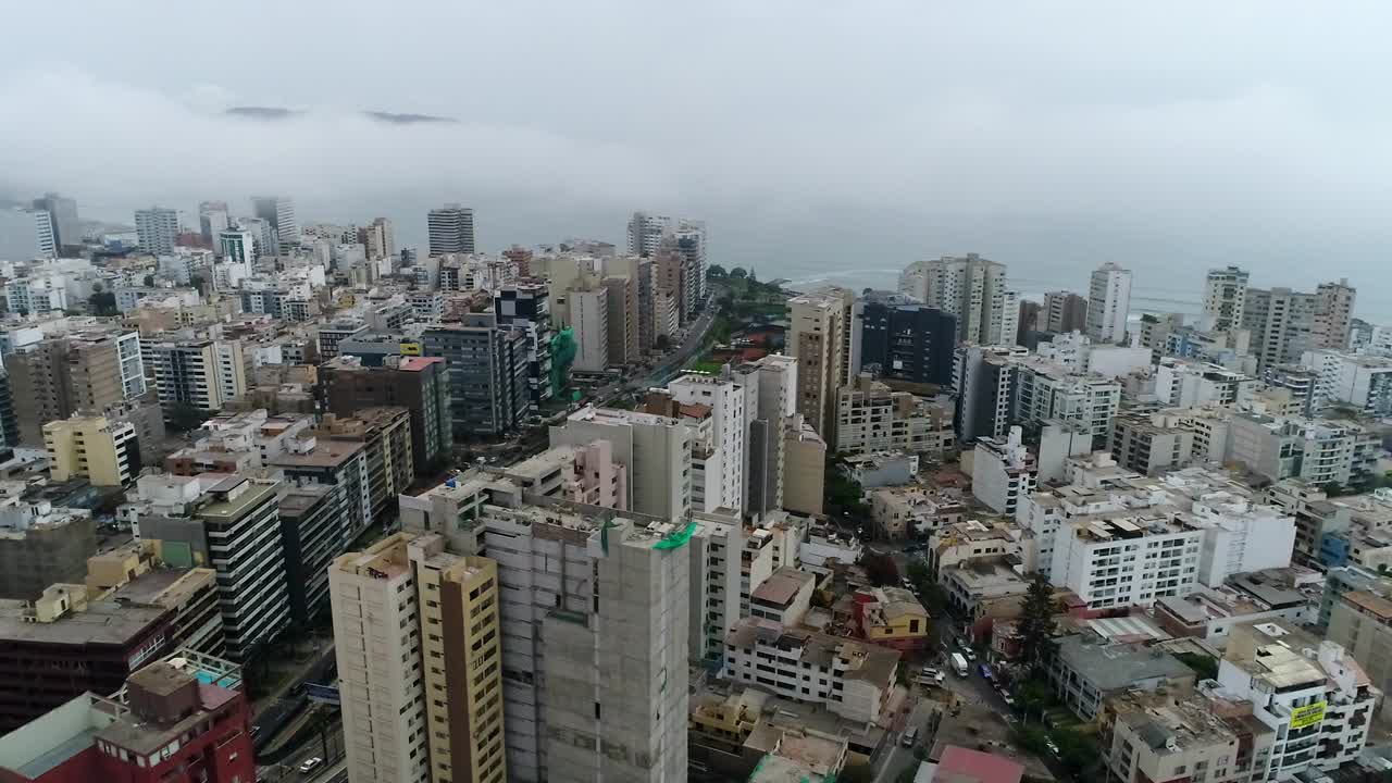 vista de drones sobre lima perú, edificios altos y el océano al fondo