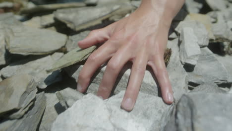 running hand across and through slate rock in slowmotion