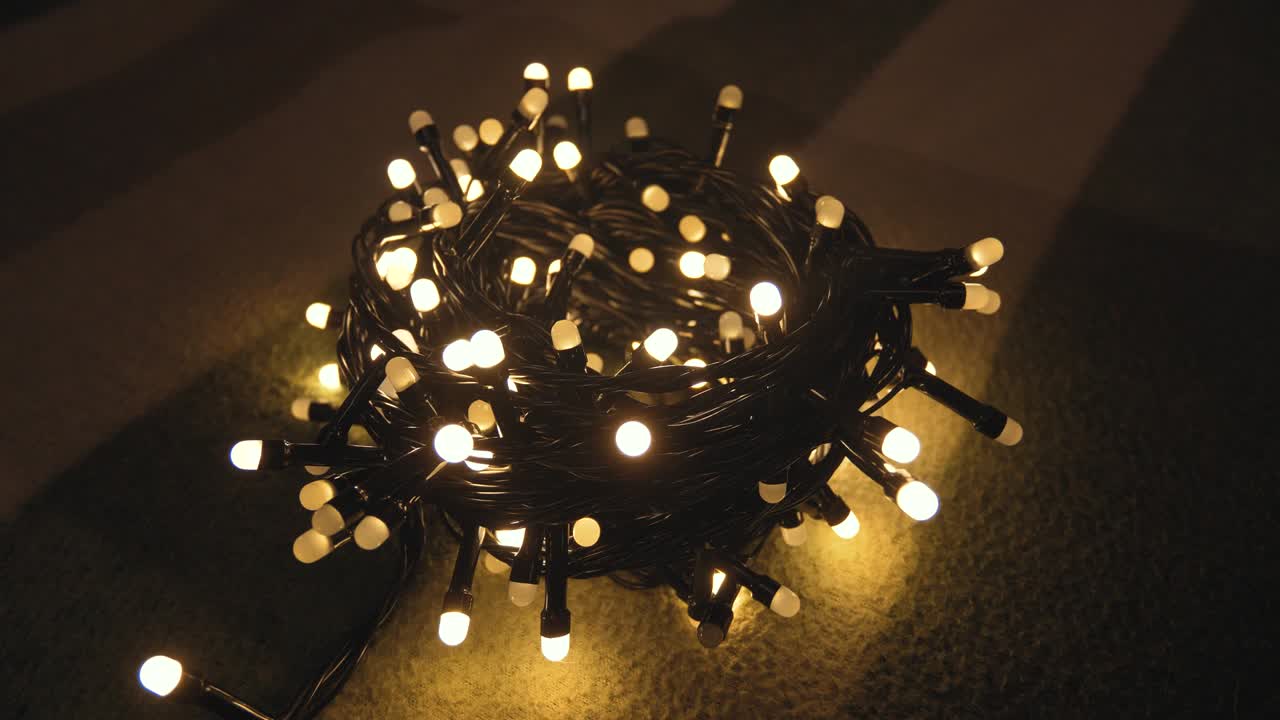 Close-up shot hank of christmas garland with golden lights on a playd. Christmas concept. Home decor