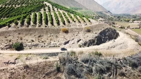 Drone-following-car-around-vineyards-in-Chilean-countryside