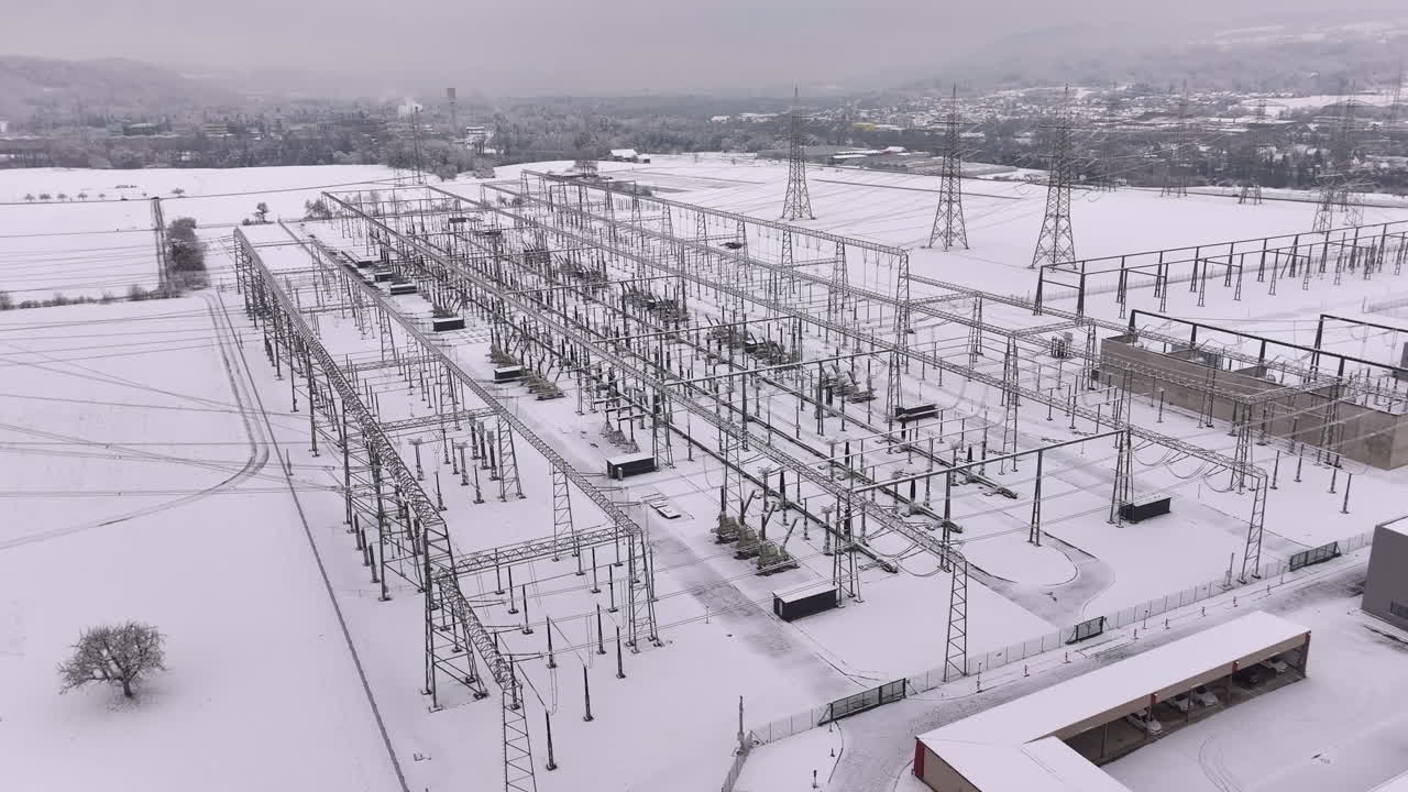 Electricity power distribution station in snowy winter landscape, drone truck shot