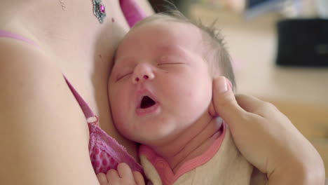 a cute newborn baby is sleeping on his mother's arms