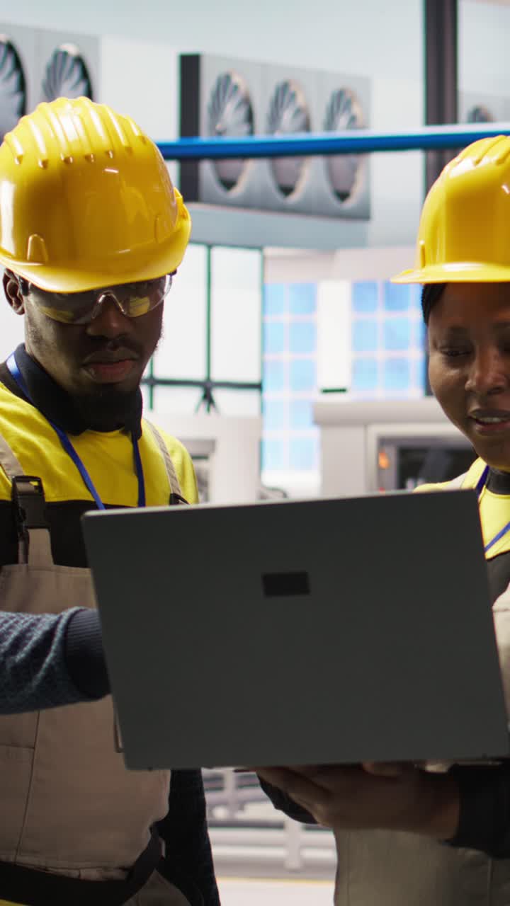 Vertical video Engineering team working together in photovoltaics factory, looking at metrics