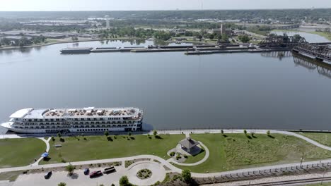 Cruise-ship-docked-on-the-Mississippi-River-in-Davenport,-Iowa-with-drone-video-moving-right-to-left