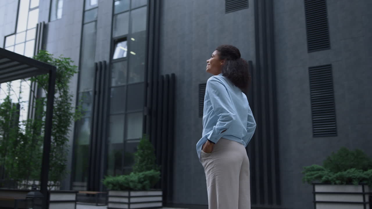 mujer de negocios sonriente de pie en el centro de la ciudad. gerente relajado inspeccionar el jardín