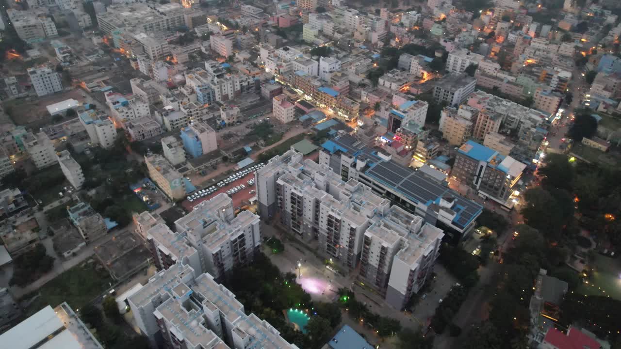 An aerial shot of Bengaluru, Karnataka's Electronic City, surrounded by opulent apartment buildings, was taken on a foggy evening in a busy residential neighborhood with parking space for cars