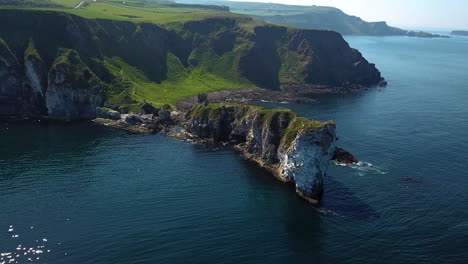 Revealing-drone-shot-of-Kinbane-Castle-in-County-Antrim,-Northern-Ireland,-on-a-long,-narrow-limestone-headland-projecting-into-the-sea