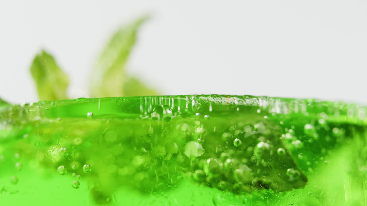 Close-up of a vibrant green soda with mint