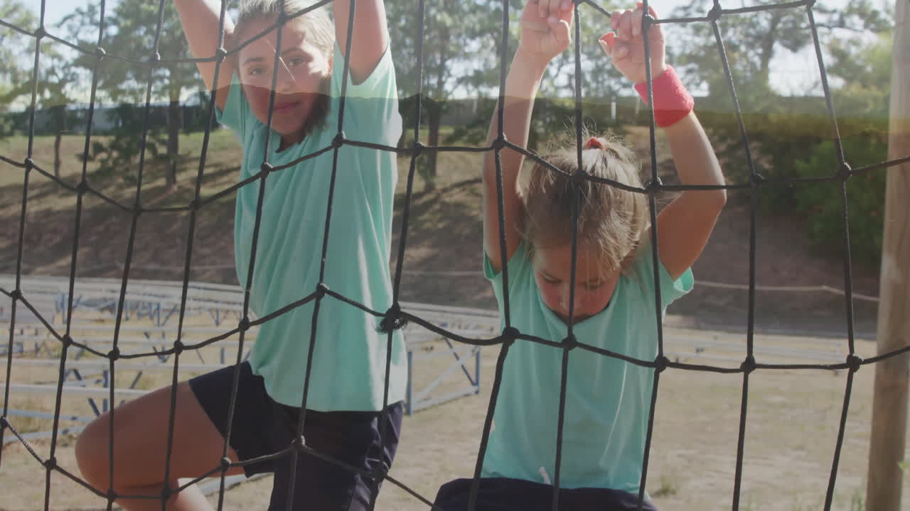 Climbing on outdoor netting, two children in sportswear at playground animation