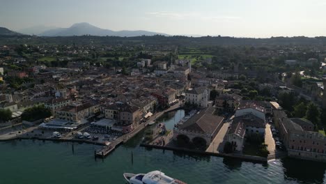 Aerial-view-of-a-yacht-pulling-up-to-the-pier-of-a-beautiful-Italian-city