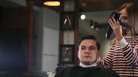 Peinado-Masculino-En-Salón.-Hombre-Secándose-El-Pelo-En-La-Barbería.-Peluquero-Peinando-El-Cabello-Con-Secador.-Terminar-La-Peluquería.-Hombre-Secador-De-Pelo-En-Barbería