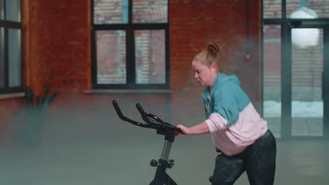 Woman-performs-aerobic-endurance-training-workout-cardio-routine-on-the-simulators,-cycle-training