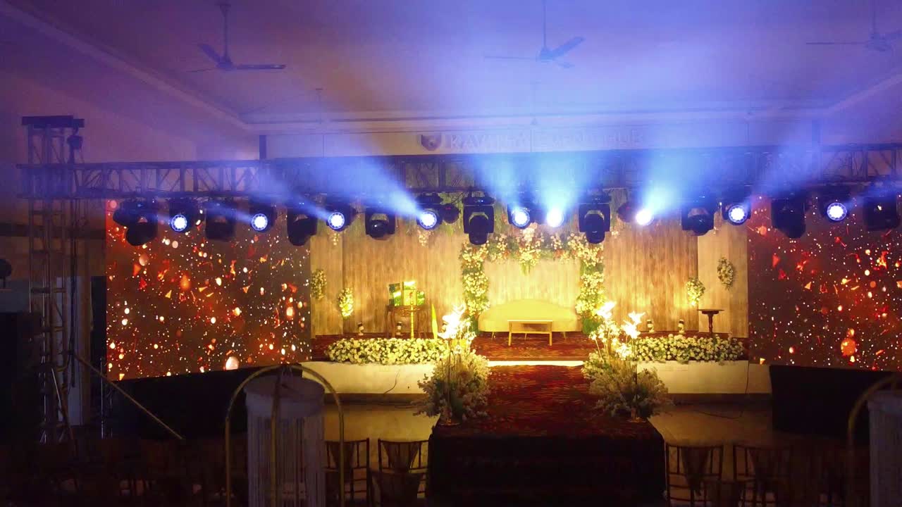 Walkthrough of a lavishly decorated event hall for a wedding reception. Stage with LED screens, floral decor, and dynamic lighting