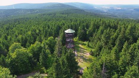 vista del tiempo del avión no tripulado mientras vuela sobre los árboles y gira alrededor y cerca de la torre de observación en las montañas con el valle en el fondo