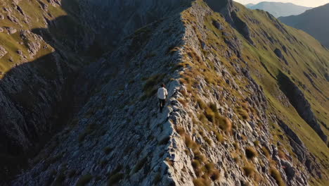 person walking along a rocky mountain ridge