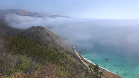 high angle of fog rolling into the coast of california near big sur