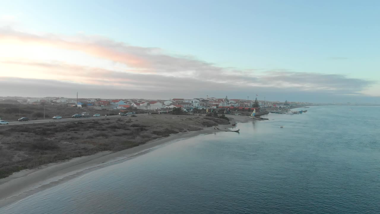Aerial view during sunset of a small village between the ocean and the river