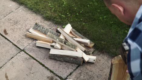 young man is chopping wood in smaller pieces