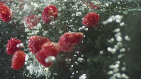 raspberries are being dropped into water