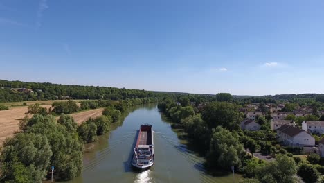 drone shot following an empty barge on a river in france. sunny day