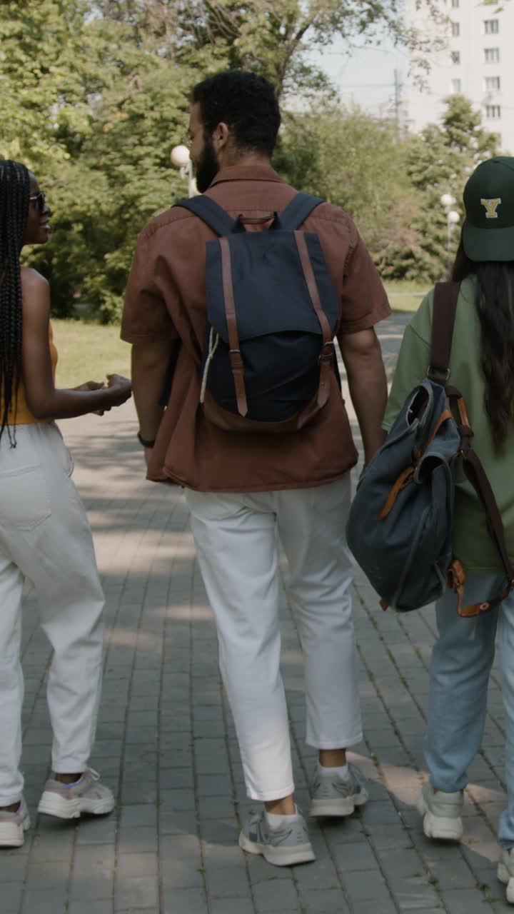 Three people walking together on a paved path outdoors