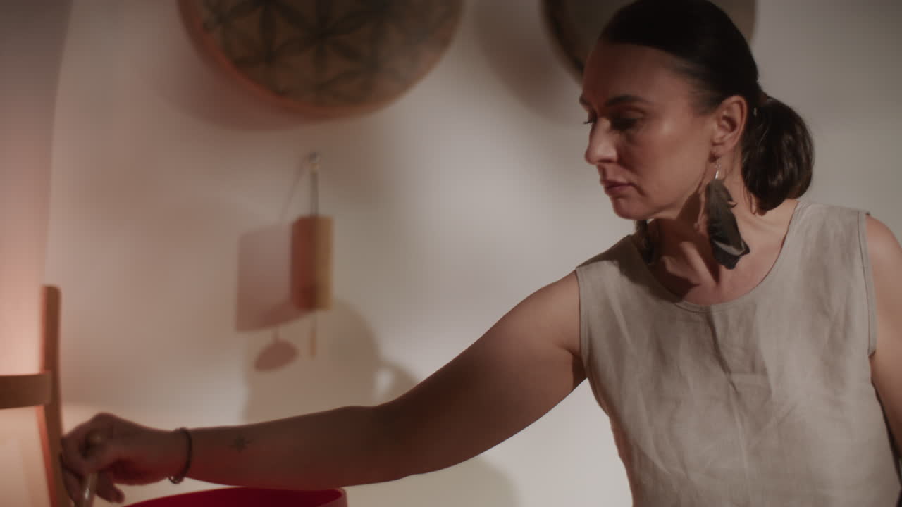 Woman practicing sound healing with crystal bowls