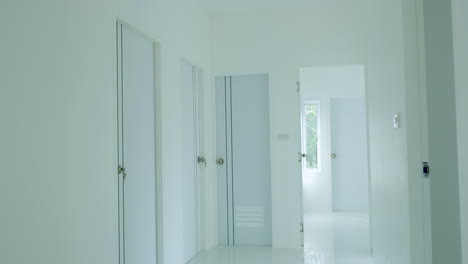 zooming out of a hallway leading to the living room of a newly built house.