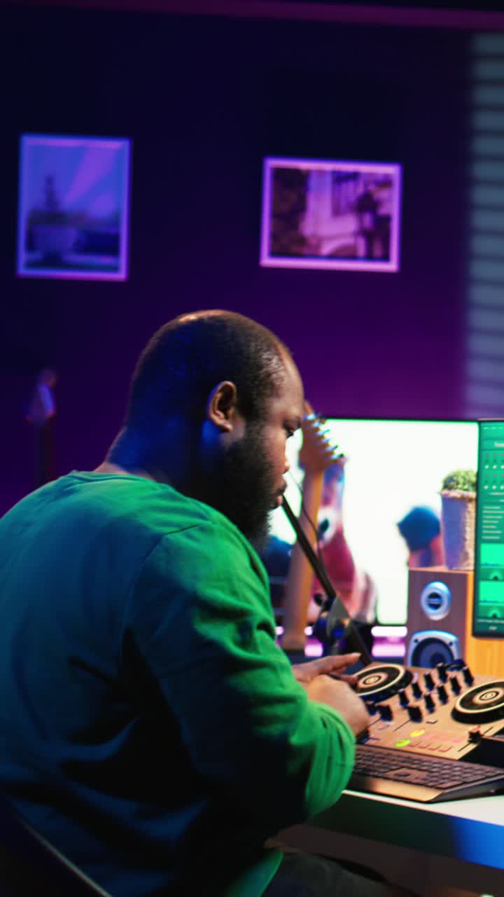 Uomo afroamericano che mixa musica su controller DJ in uno studio buio