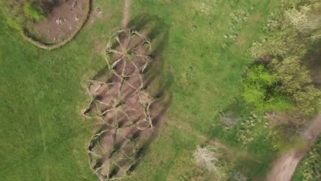 4K-willow-cathedral-live-sculpture-made-of-willow-trees-in-Taunton-Somerset,-60fps-drone-moving-forward-and-rotating-to-the-left-over-the-tree-cathedral