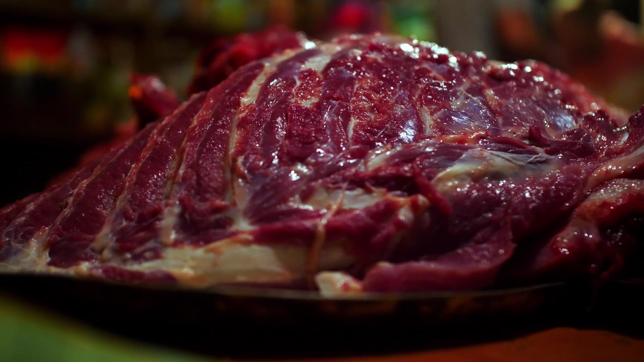 Lastra di carne cruda di costato di maiale del peso di 100 libbre in un dettaglio ravvicinato. Macelleria tradizionale, preparazione del maiale kalua e lavorazione della carcassa per barbecue per un banchetto luau. Video cinematografico in 4K