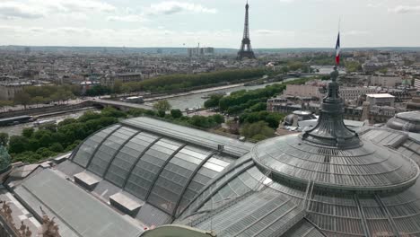 Glass-roof-and-dome-of-Grand-Palais-or-Great-Palace-with-Tour-Eiffel-tower-in-background,-Paris-cityscape,-France