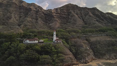 Aerial-view-of-Lighthouse-against-mountains-on-sunny-day-dolly-right