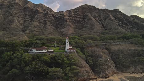 vista aérea del faro contra las montañas en el día soleado dolly right