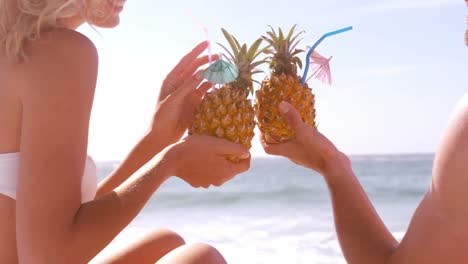 pareja sonriente bebiendo en una piña