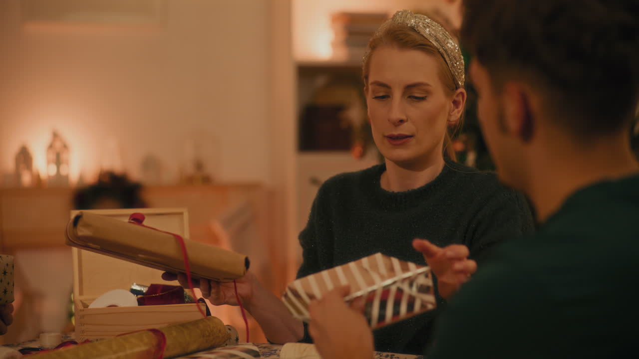 mujer mostrando el regalo de navidad a un amigo masculino